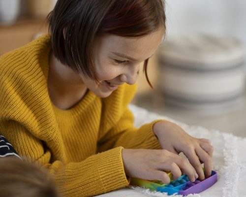 close-up-child-playing-with-pop-it-toy