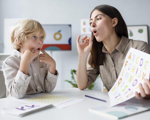 woman-doing-speech-therapy-with-little-blonde-boy